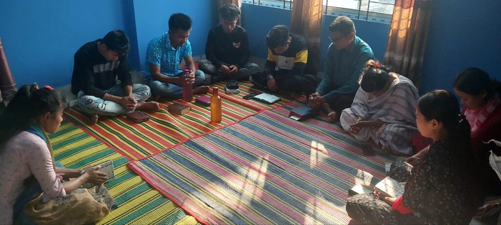 BCBT Bible study participants seated together around a striped floor mat